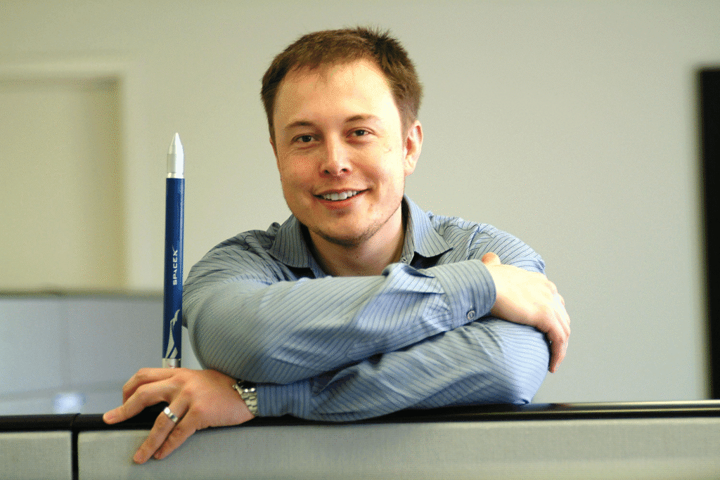 Elon Musk holding SpaceX miniature rocket